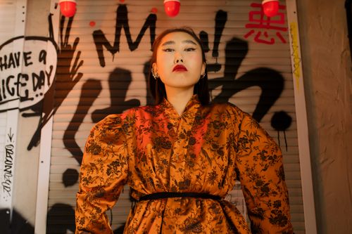 Free Stylish woman in kimono poses confidently against vibrant graffiti, juxtaposing traditional and urban aesthetics. Stock Photo