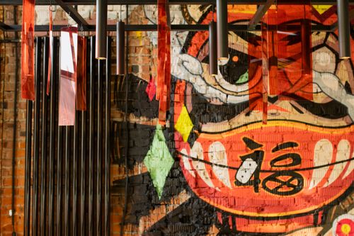 Free Colorful graffiti mural with modern hanging lights creates a vibrant urban art decor. Stock Photo