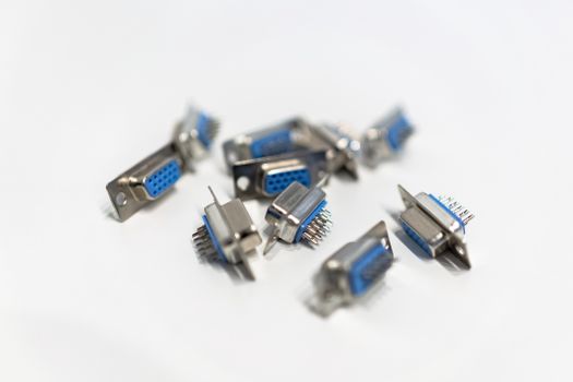 A close-up view of blue VGA connectors scattered on a white surface, highlighting hardware details.