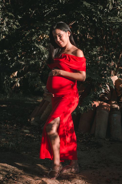 Free Pregnant Woman in Red Dress Looking at Camera Stock Photo
