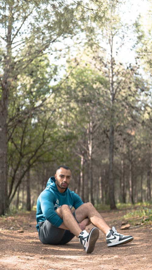 Free Young man sits on forest trail in Fes, Morocco, wearing a blue hoodie. Stock Photo