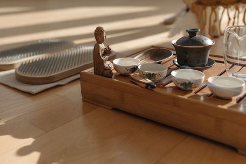 Free A calming bamboo tea ceremony setup with teacups and a Buddha statue on a wooden tray. Stock Photo