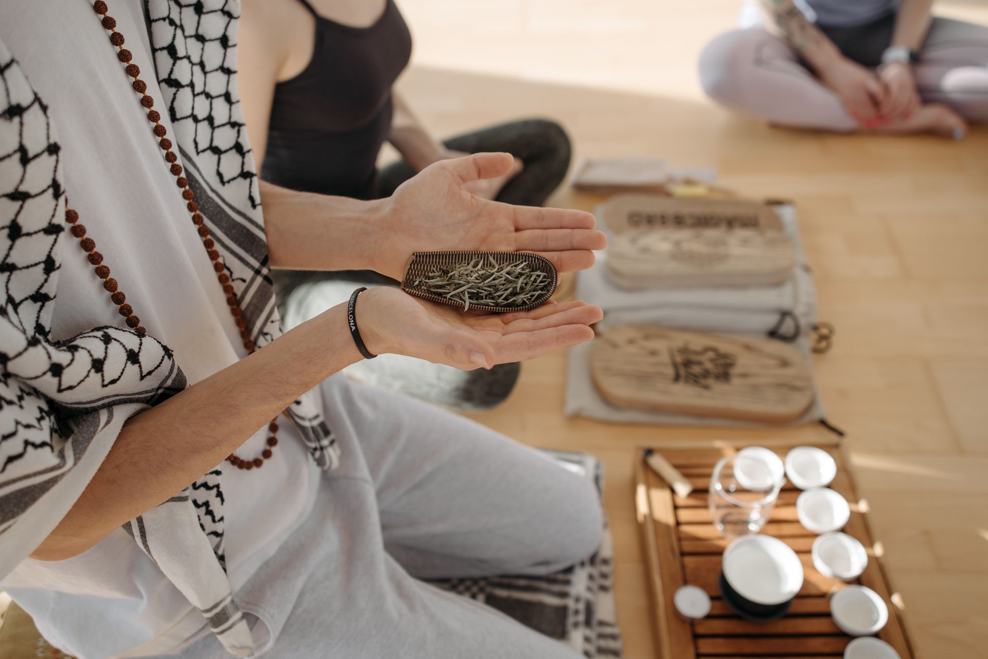 Man and Woman Kneeling and Holding Herbs in Hands