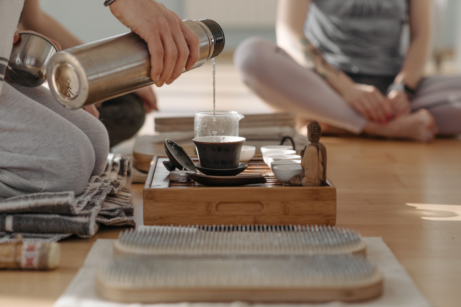 A Hand Pouring Hot Water on a Teapot