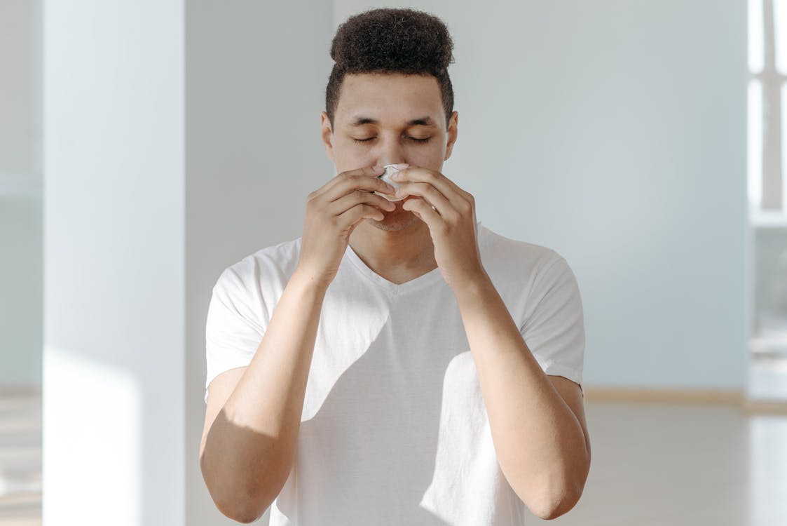 Free Sick Man in White Shirt Wiping His Nose with Tissue Stock Photo