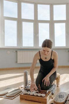 A woman practicing mindfulness through a tea ceremony indoors, focusing on wellness and relaxation.