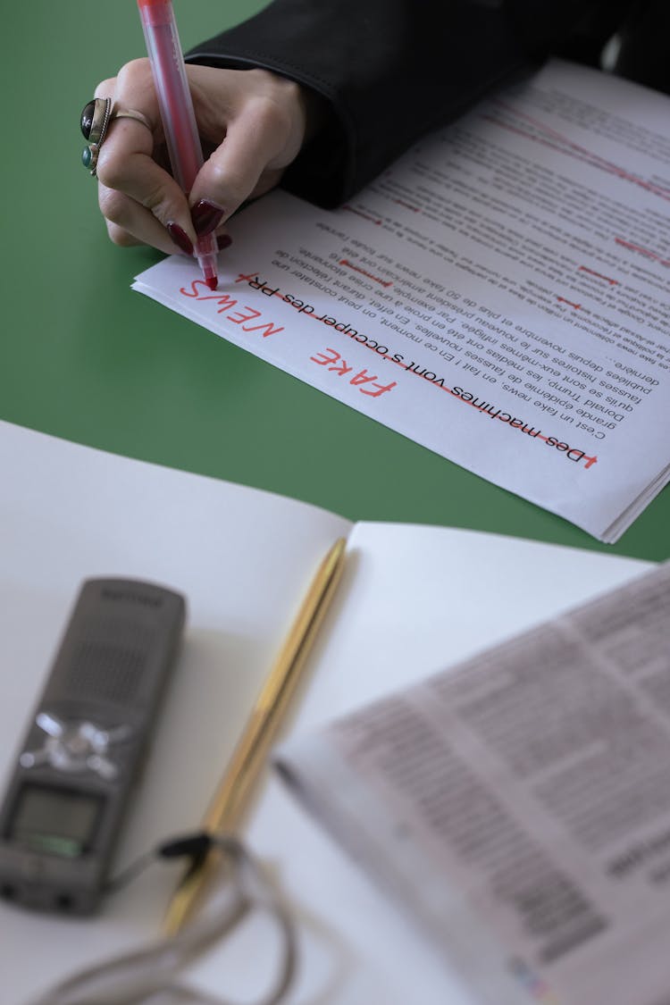 A Hand Correcting Some Words On The Document