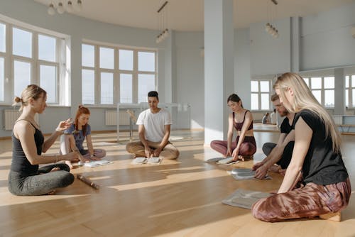 Group of People Sitting on Brown Wooden Floor