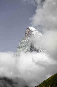 Discover the breathtaking Matterhorn peak piercing through dense clouds, a symbol of natural grandeur.