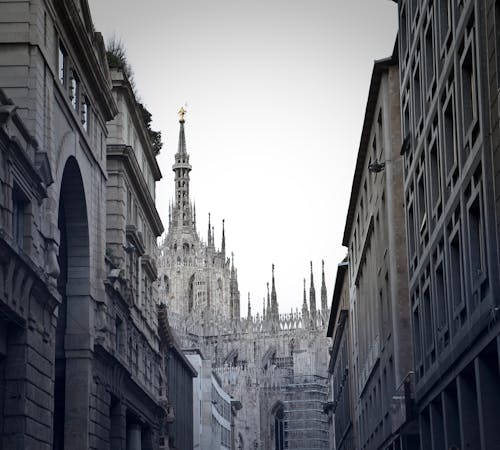 Foto Grayscale Dari Gang Dengan Katedral Milan Di Background