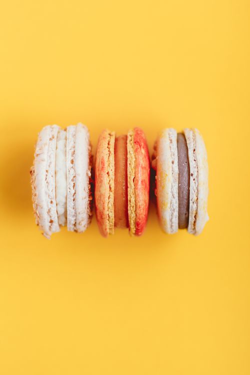 Free Top view of delicious sweet macaroon with different cream placed on bright yellow background Stock Photo
