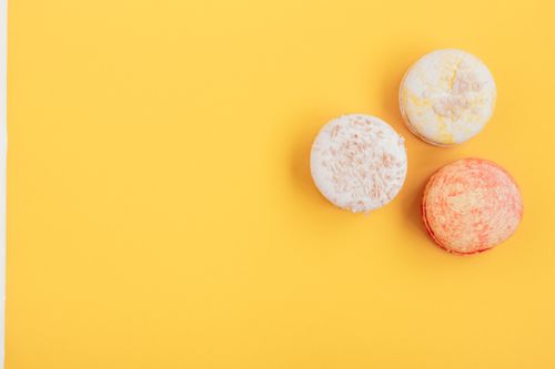 Free Top view of tasty sweet gentle round macaroons with seeds placed on vivid yellow background of studio Stock Photo