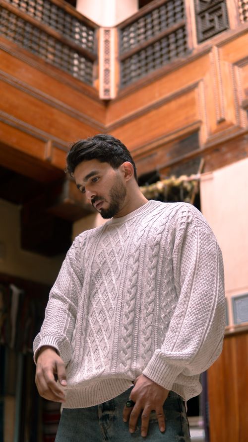 Free Man in a cozy white sweater in traditional Moroccan architecture, Fes. Stock Photo