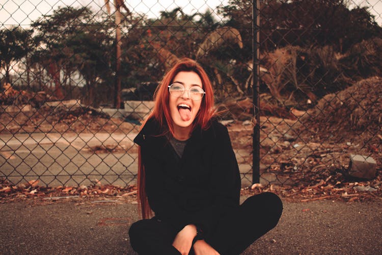 Playful Woman With Tongue Out On Pavement