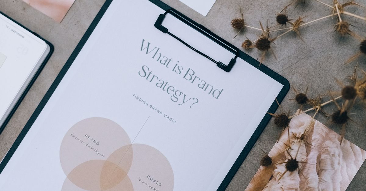 Overhead view of brand strategy documents with artistic visuals for business planning.