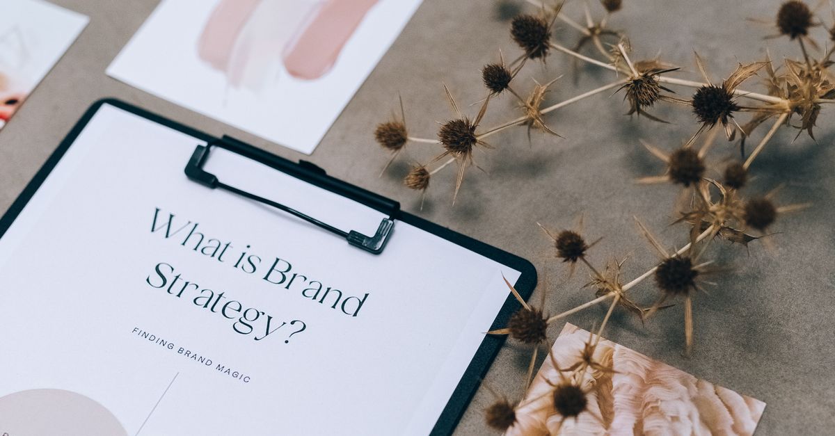Elegant flat lay of branding strategy documents with a natural twig accent.