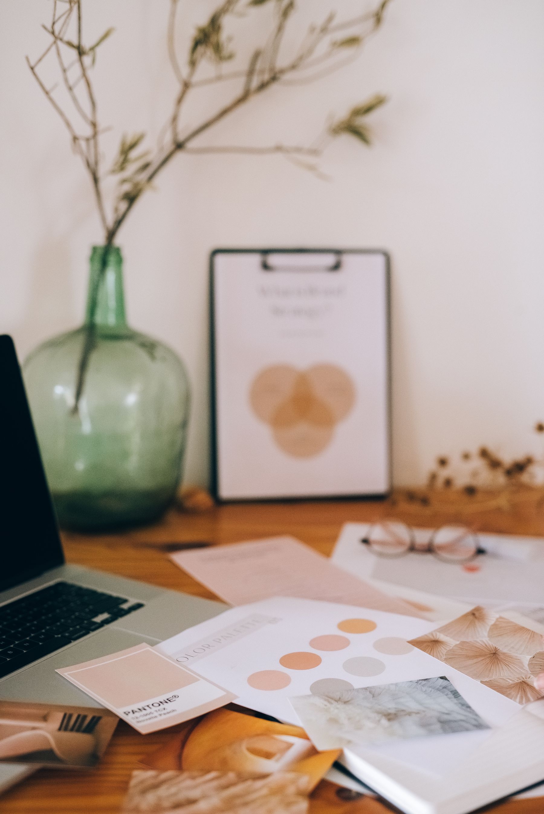 Brand documents, printed materials and a laptop arranged on a desk