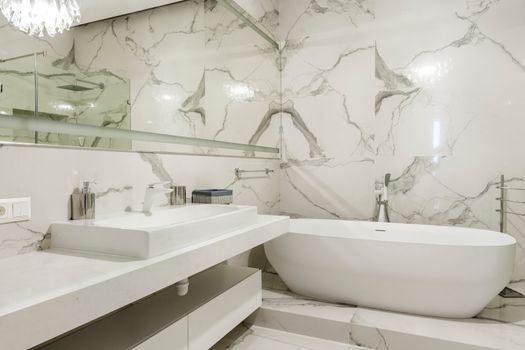 Elegant marble bathroom with freestanding bathtub and minimalist design.