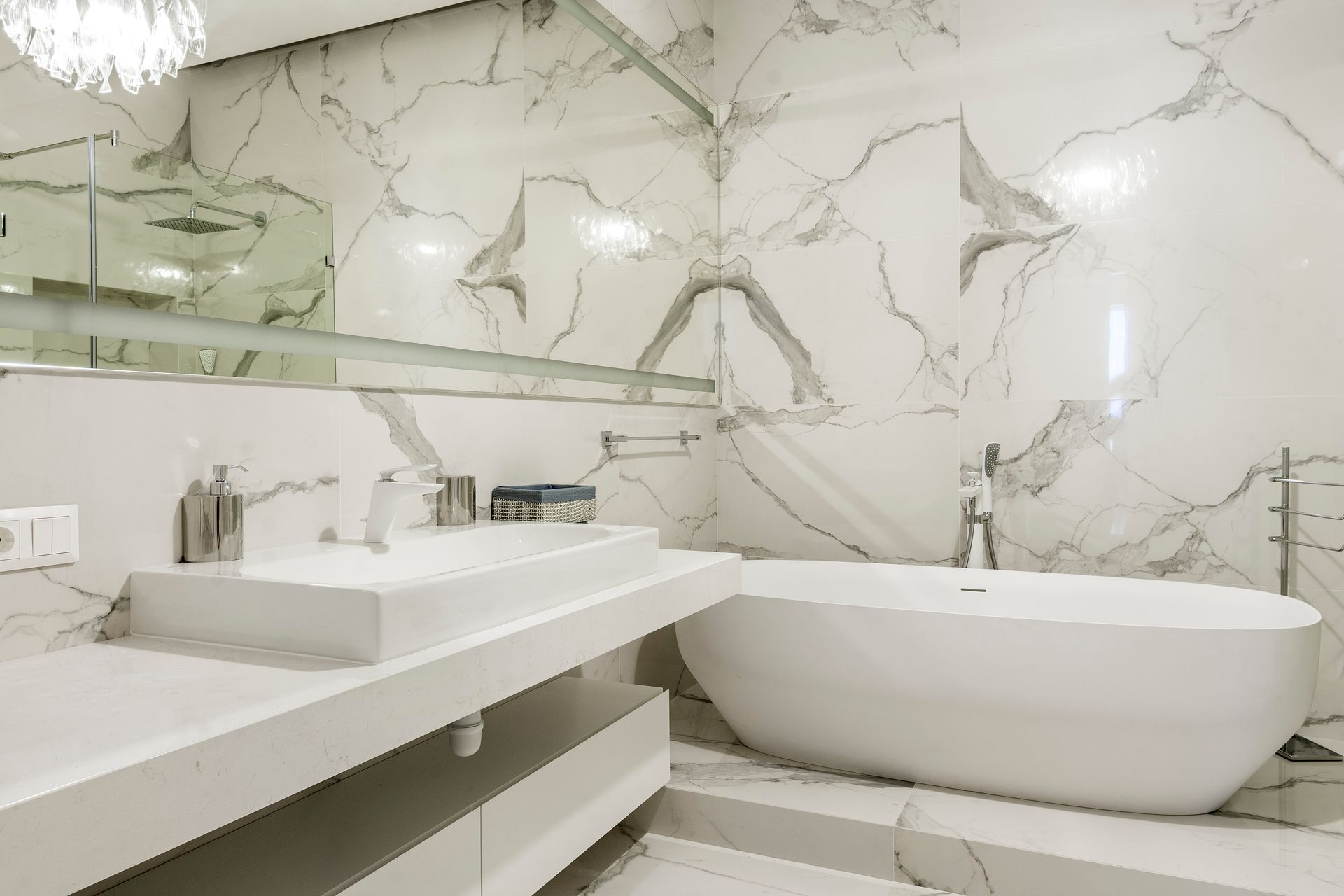 Elegant marble bathroom with freestanding bathtub and minimalist design.