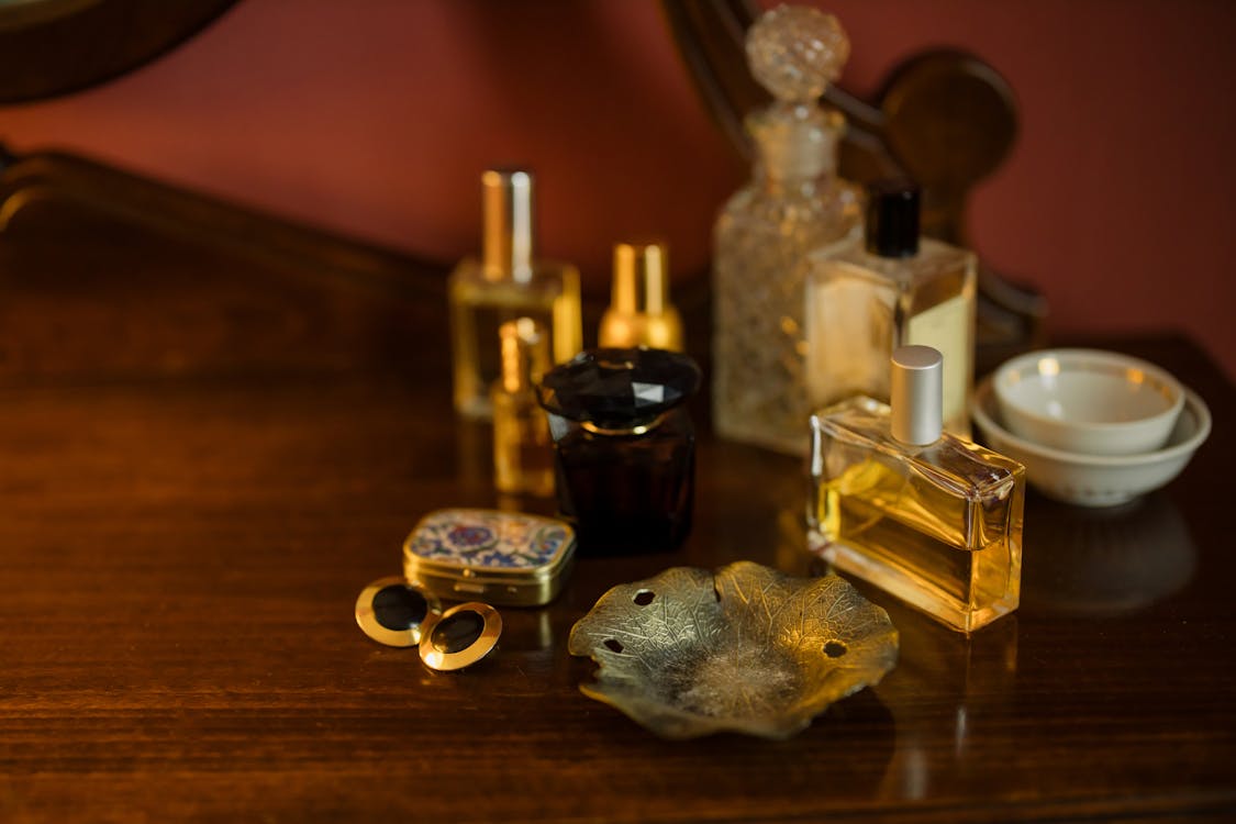 A bottle of perfume sitting on top of a table photo – Free Perfume