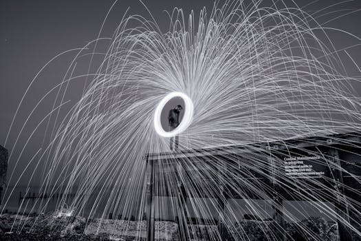 A captivating black and white long exposure photo of a fireworks display at night over a boardwalk.