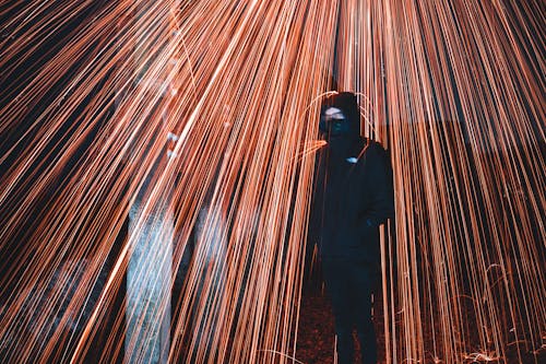 A Person in Hoodie Sweater Standing Near a Firework