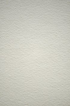 A close-up view of a textured paper surface showing subtle patterns and a vertical layout.