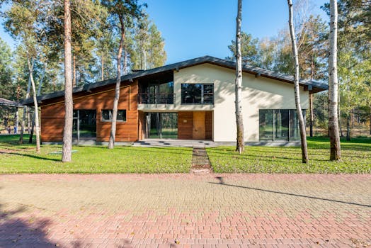 Contemporary house facade set amidst lush greenery and trees.