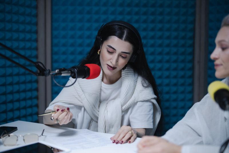 Hosts recording a radio show with professional microphones