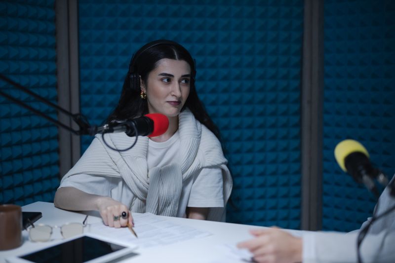 Two hosts recording a true-crime episode with studio microphones