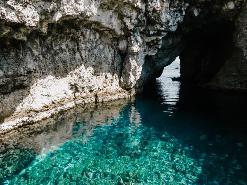 Free Explore the vibrant waters and rugged rock formations of a coastal cave in Il-Mellieħa, Malta. Stock Photo