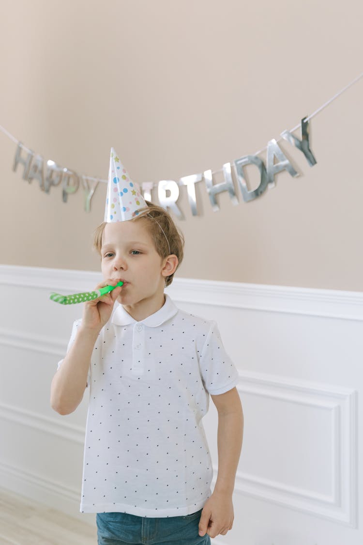 A Boy Blowing A Party Horn