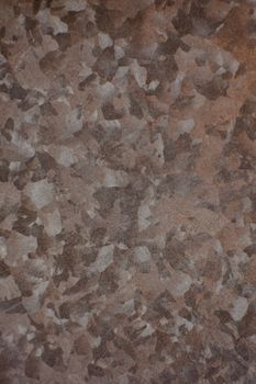Close-up of a galvanized metal surface displaying a textured, camouflage-like pattern.