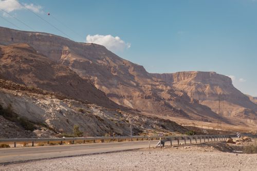 Free Empty straight narrow asphalt roadway running along mountain dry terrain under blue clear sky on sunny day Stock Photo
