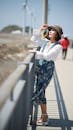 Woman in Blue Floral Skirt Looking up on a Bridge