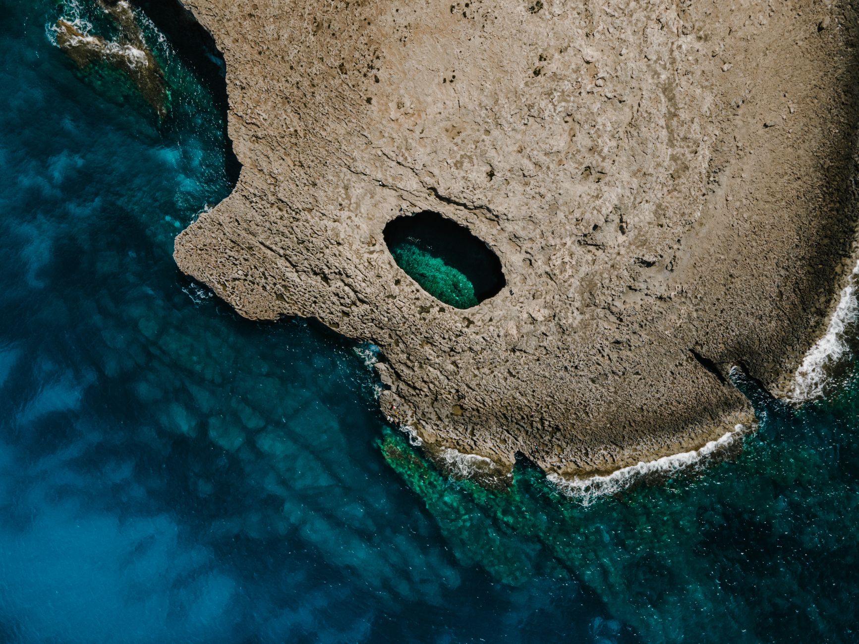 Stunning aerial shot of a rock formation with a natural pool in Il-Mellieħa, Malta.. Photo by Polina ⠀ on Pexels