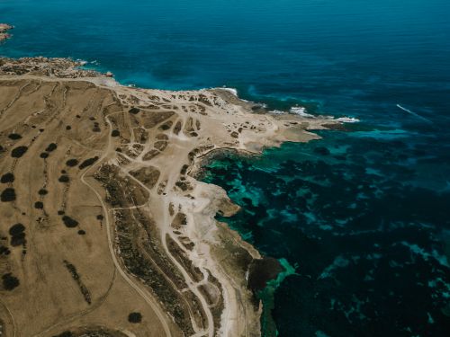 Free Drone shot of the stunning coastline of Mellieha, Malta showcasing turquoise waters and rugged cliffs. Stock Photo