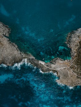 Breathtaking aerial view of Malta's coastline with turquoise waters and rocky shores. Perfect for travel inspiration.