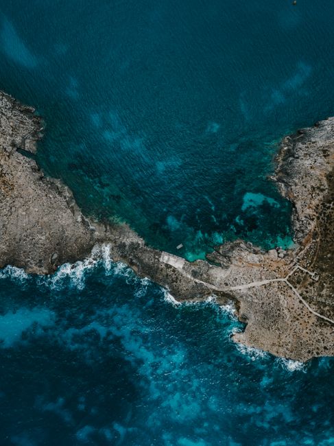 Breathtaking aerial view of Malta's coastline with turquoise waters and rocky shores. Perfect for travel inspiration.