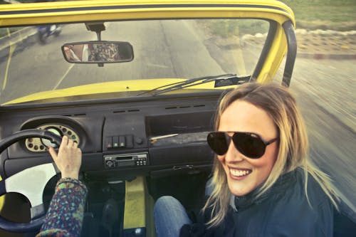 Gratis Woman In Black Aviator Sunglasses Duduk Di Kursi Penumpang Mobil Foto Stok