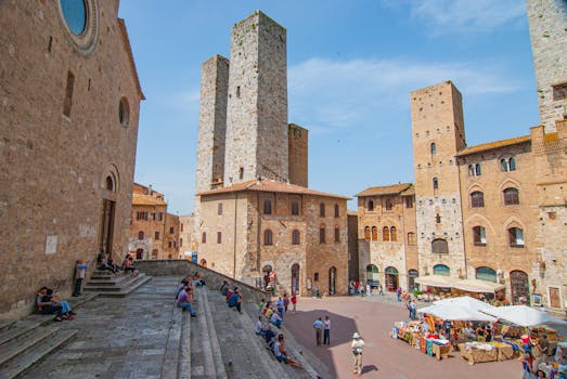 Tourists enjoy the historic Piazza del Duomo in San Gimignano, Tuscany.