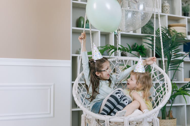 Young Girls Sitting On A Swing