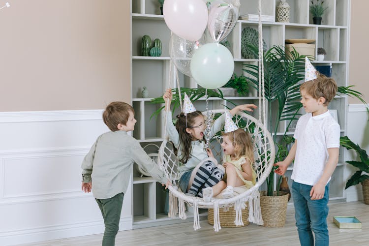 Children In A Living Room With A Hanging Chair