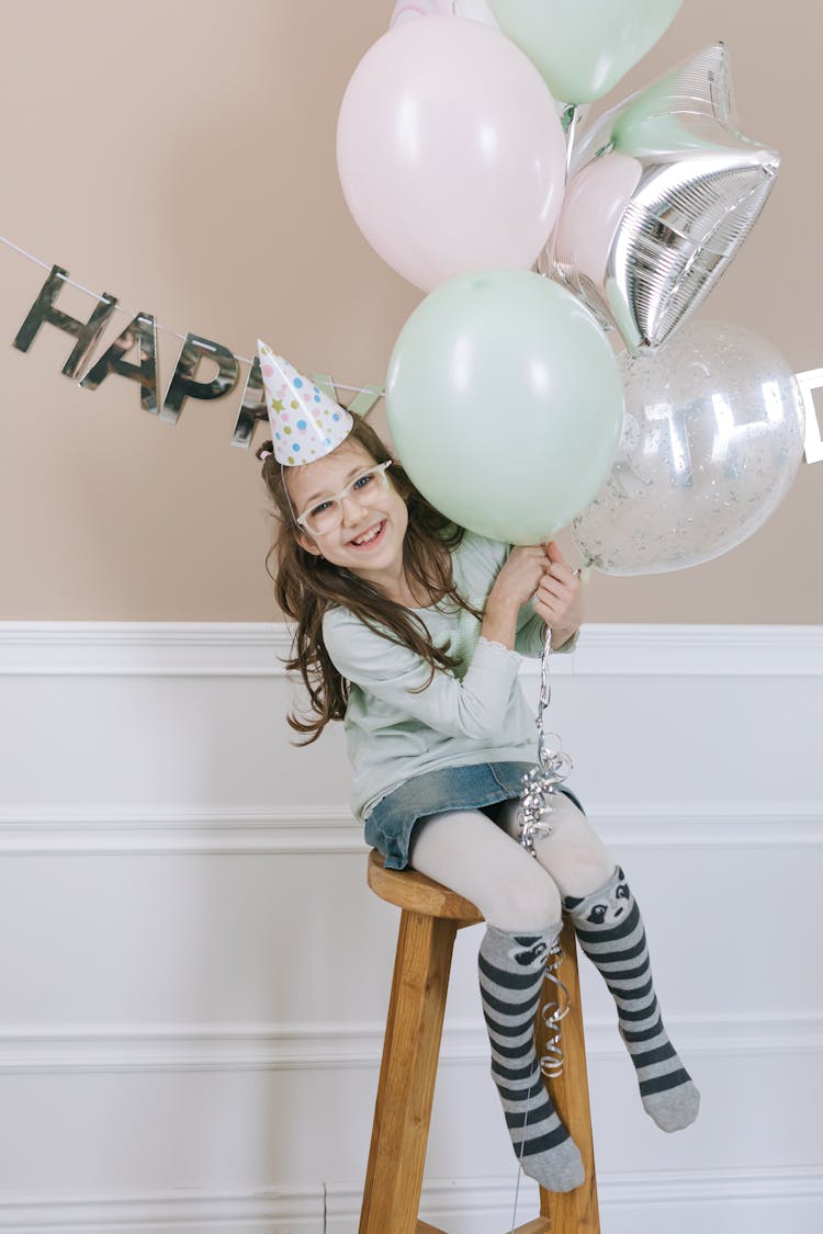 A Birthday Girl Holding Balloons