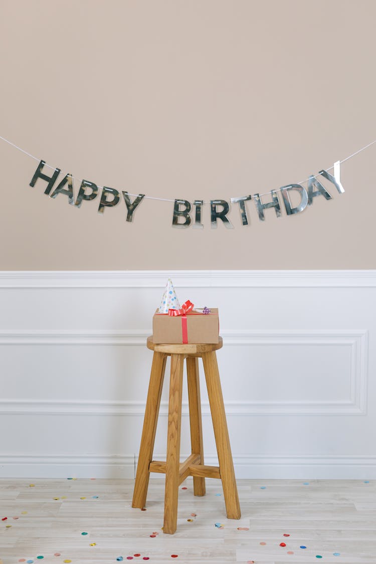 Gift On A Stool Beside A Birthday Banner