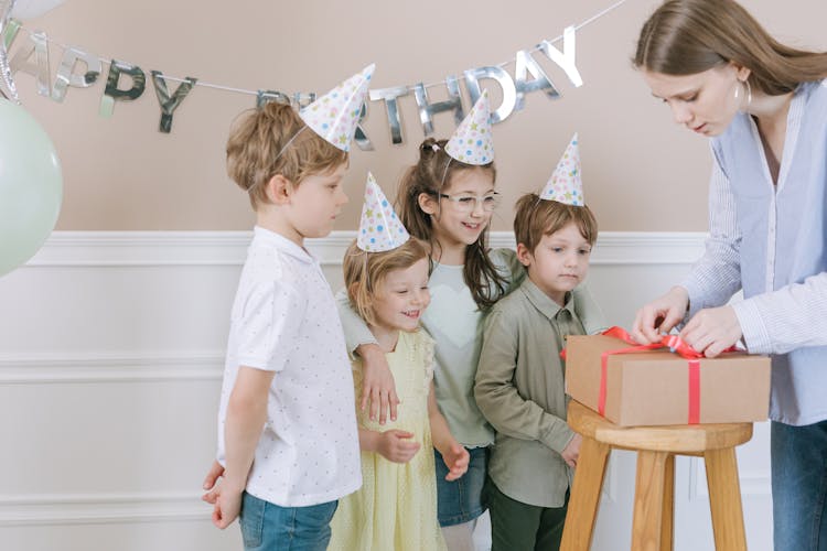 Children Looking At A Present Being Opened