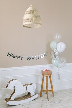 Charming birthday setup with balloons, a banner, and a toy horse indoors.