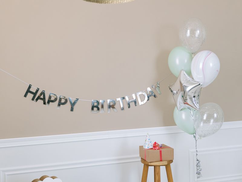 Kids birthday setup with balloons, banner and rocking horse