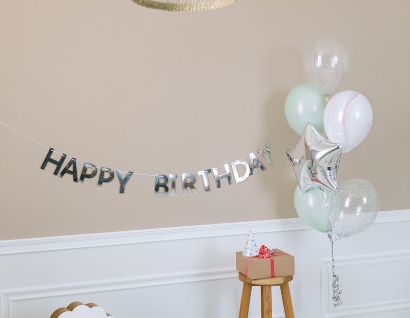Kids birthday setup with balloons, banner and rocking horse