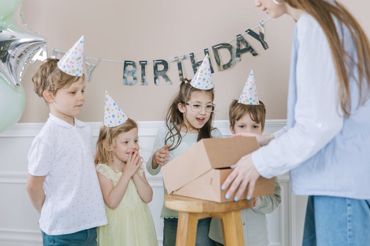 Woman Opening A Gift With The Kids